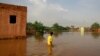 A boy wades through a flooded street in the area of al-Qamayir in the capital's twin city of Omdurman, Sudan, Aug. 26, 2020. 