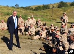 FILE - Defense Secretary Jim Mattis talks to U.S. Marines at a rifle range at Guantanamo Bay, Cuba, Dec. 21. 2017.