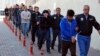 In this photo taken on April 26, 2017, Police officers escort people, arrested because of suspected links to U.S.-based cleric Fethullah Gulen, in Kayseri, Turkey. 