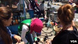 Garment workers buy food during a lunch break on national road #2 in Meanchey district, Phnom Penh, Cambodia. (Photo: Phorn Bopha/VOA Khmer)