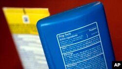 FILE - Sunscreen ingredients, including oxybenzone, are shown, in San Jose, Calif., May 2, 2018. In an attempt to protect the coral reefs, the Pacific nation of Palau will soon ban many types of sunscreen. The law defines reef-toxic sunscreen as containin