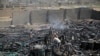FILE - Workers salvage oil canisters from the wreckage of a vehicle oil store hit by Saudi-led airstrikes in Sanaa, Yemen, July 2, 2020.