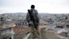 FILE - A Syrian Kurdish sniper looks at the rubble in the Syrian city of Ain al-Arab, also known as Kobani, Jan. 30, 2015.