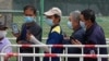 Residents wearing face masks to help curb the spread of the coronavirus look at their smartphones showing health code as they line up to receive the Sinopharm COVID-19 vaccine at a vaccination center in Central Business District in Beijing on…