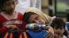 Asylum seekers hoping to reach Australia, wait in a police station in Surabaya , East Java province July 29, 2012. 