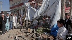  Afghans look at wreckage after a roadside bomb explosion went off on the outskirts of Kabul, Afghanistan, Sunday, Oct. 27, 2013.
