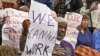 FILE - US citizens hold signs appealing for jobs as they attend a Democratic news conference about extending unemployment insurance benefits which expired Dec. 28, on Capitol Hill in Washington.