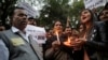 The father, left and mother, center, of the Indian student victim who was fatally gang raped on this day three years ago on a moving bus in the Indian capital, join others at a candle lit vigil in New Delhi, India, Dec. 16, 2015. 