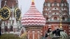 People take photos in front of the Kremlin's Spasskaya tower and St. Basil's cathedral in downtown Moscow on Nov. 10, 2023.