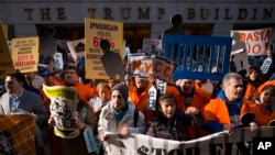 Protesters march on Wall Street, Tuesday, May 1, 2018, in New York. Workers and activists marked May Day with rallies around the world to demand their government address labor issues.