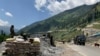 FILE - Indian paramilitary soldiers keep guard as an Indian army convoy moves along the Srinagar-Ladakh highway at Gagangeer, India, June 18, 2020, as a standoff between India and China over the Himalayan Galwan Valley escalates.