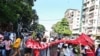 Protesters taking part in a demonstration against the military coup run as security forces launched a crackdown on the protest in Yangon, Myanmar, Dec. 5, 2021. 