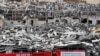 FILE - A worker sets banners at the port warehouses that were destroyed by Aug. 4 explosion that hit the seaport of Beirut, Lebanon, Aug. 19, 2020. 