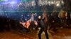 Un manifestant masqué lance un objet en direction de la police lors d'un rassemblement devant le parlement à Tbilissi, en Géorgie, 1er décembre 2024. AP / Zurab Tsertsvadze