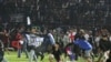 Arema FC supporters enter the field after the team they support lost to Persebaya after a football match at Kanjuruhan Stadium