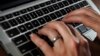 FILE- In this June 19, 2017, photo, a person types on a laptop keyboard.