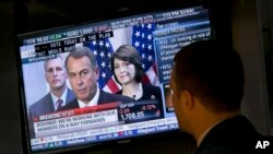 El especialista Frank Masiello escucha las declaraciones del John Boehner en la televisión mientras trabaja en la Bolsa de Valores de Nueva York.