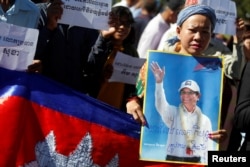 FILE - Supporters of Kem Sokha, leader of the Cambodia National Rescue Party, stand outside the Appeal Court during a bail hearing for the jailed opposition leader in Phnom Penh, Sept. 26, 2017.
