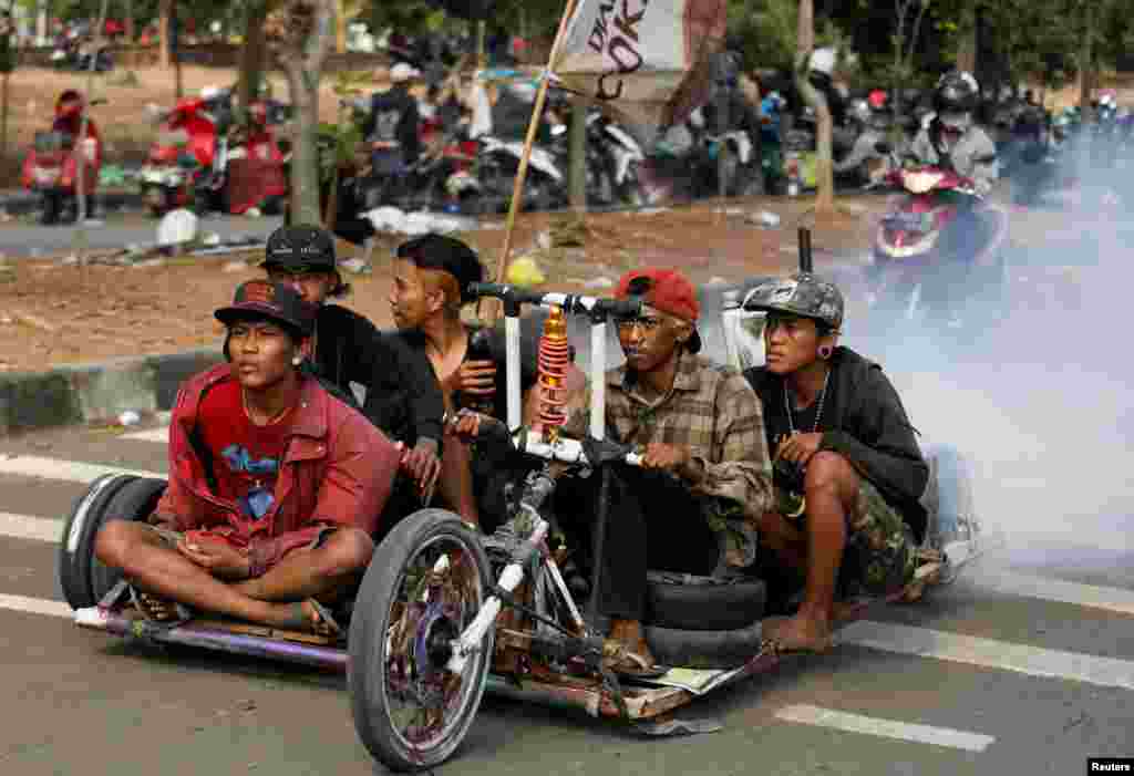 អ្នកនិយមម៉ូតូ Vespa បើកម៉ូតូរបស់ខ្លួននៅក្បែរកន្លែងប្រារព្ធពិធីចុងសប្តាហ៍សម្រាប់អ្នកនិយមម៉ូតូ Vespas ខ្លាំងក្នុងទីក្រុង Semarang ទីក្រុង Java កណ្តាល ប្រទេសឥណ្ឌូណេស៊ី។