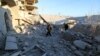 Residents inspect damage after airstrikes by pro-Syrian government forces in Anadan city, about 10 kilometers away from the towns of Nubul and Zahraa, Northern Aleppo countryside, Feb. 3, 2016.