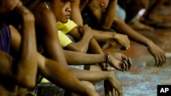 Rounded up residents wait to be transported to a police station in the continuing operation of President Rodrigo Duterte's so-called "War on Drugs" campaign, at the slum community of Tondo, in Manila, Philippines, Sept. 30, 2016.