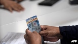 Una mujer recibe dinero de un empleado en el centro de Ciudad de México, el 17 de julio de 2020, en medio de la pandemia del nuevo coronavirus. 