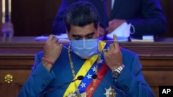 Le président vénézuélien Nicolás Maduro enlève son masque alors qu'il se prépare à parler devant les législateurs à l'Assemblée nationale, Caracas, 12 janvier 2021.