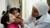 FILE - A health worker administers polio vaccine to a child as part of a UNICEF-supported vaccination campaign at the Abou Dhar Al Ghifari Primary Health Care Center in Damascus, Syria, Oct. 29, 2013.