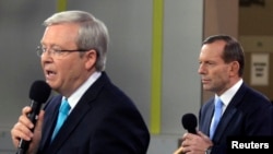 Opposition leader Tony Abbott (R) listens to Australian Prime Minister Kevin Rudd during the People's Forum in Sydney, Aug. 28, 2013. 