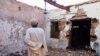Hajj Ahmed, um residente do bairro de Old-Omdurman, olha para a sua casa depois de esta ter sido danificada por obuses em Omdurman. Fotografia de arquivo
