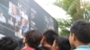 Primary school students in Anlong Veng look and read a banner about Khmer Rouge, placed inside Anlong Veng district hall compound, January 5, 2019. (Sun Narin/VOA Khmer) 