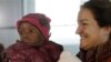 Seorang ibu warga Perancis menggendong anak adopsinya dari Haiti di bandara Roissy, Paris.