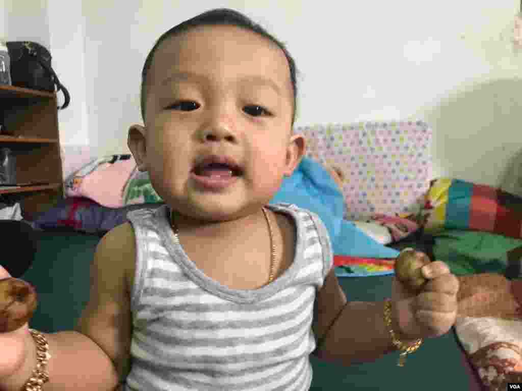 Kem Virakbot, at 9 months old, smiles for the camera, as his mother, Bou Rachana, talks to VOA Khmer's reporter Sok Khemara, July 2, 2017. (Sok Khemara/VOA Khmer)