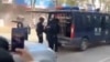 Security officers stand near a police vehicle following an explosion after artillery shells fell in Nansan, Yunnan Province, China, in this screengrab obtained from a social media video, released on Jan. 3, 2024.