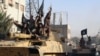 FILE- This undated image posted by the Raqqa Media Center, a Syrian opposition group, on June 30, 2014, which has been verified by AP, shows fighters from the al-Qaida-linked Islamic State group during a parade in Raqqa, Syria. 