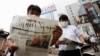 Men read extra editions of a newspaper reporting Japanese Chief Cabinet Secretary Yoshihide Suga won in a ruling party leadership election paving the way for him to replace Prime Minister Shinzo Abe in Tokyo