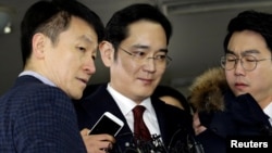 FILE - Jay Y. Lee (center) vice chairman of Samsung Electronics, arrives to be questioned as a suspect in bribery case in the influence-peddling scandal that led to the president's impeachment at the office of the independent counsel in Seoul, South Korea, Jan. 12, 2017. 