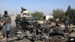 FILE - Afghan security forces inspect the site of a U.S. airstrike in Kunduz city, north of Kabul, Afghanistan, Oct. 2, 2015.