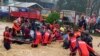 This handout photo taken on Dec. 16, 2021 and received from the Philippine Coast Guard shows rescue workers evacuating residents from their flooded homes in Cagayan de Oro City, on the island of Mindanao. (Photo by Handout / Philippine Coast Guard) 