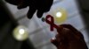 Une infirmière donne un ruban à une femme, pour la journée de lutte contre le sida, à Sao Paulo, le 1er décembre 2014.