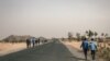 Des lycéens marchent sur la route de Mokolo à Maroua, Région de l'Extrême-Nord, Cameroun, le 20 février 2018. / AFP PHOTO / ALEXIS HUGUET