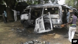 Des hommes examinent un bus après une explosion à Potiskum, Nigéria, le 24 février 2015. 