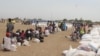 Displaced South Sudanese wait on Saturday, March 21, 2015, in Ganyiel, Unity state for sacks of food provided by the World Food Program (WFP) to be distributed. 