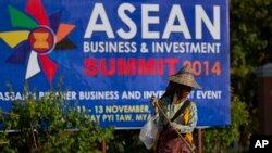 A sweeper cleans a road in the foreground of a billboard promoting Association of Southeast Asian Nations (ASEAN) summit in Naypyitaw, Myanmar, Tuesday, Nov 11, 2014. Myanmar hosts the ASEAN summit and related meetings on Nov. 12 and 13. (AP Photo)
