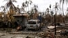 FILE - A car is seen near a house that was burnt down during the last days violence in Maungdaw, Myanmar Aug. 31, 2017.