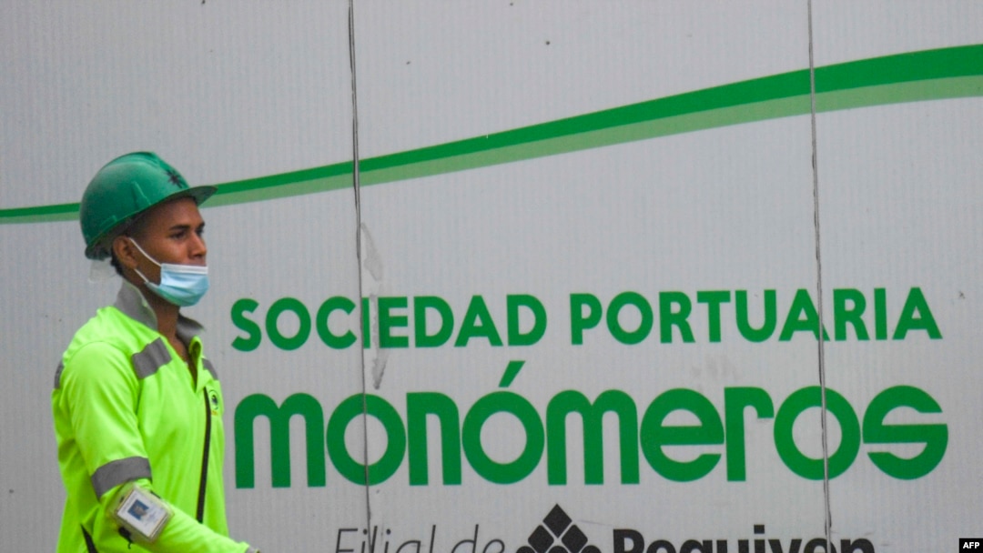 Un trabajador pasa frente a un cartel de la empresa venezolana de fertilizantes Monómeros, en Barranquilla, Colombia, el 9 de octubre de 2021.