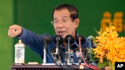 Cambodia's Prime Minister Hun Sen speaks to garment workers during a visit to a factory outside Phnom Penh, Cambodia, Wednesday, Aug. 30, 2017. Hun Sen is on a country-wide trip visiting the nation's factory workers to hear their hopes and concerns in person. (AP Photo/Heng Sinith)