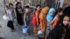 FILE - Iraqi children, most of them internally displaced persons, wait in line for free food being distributed at a mosque in Baghdad, Iraq, June 23, 2015.