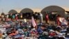 FILE - Displaced Iraqis from the Yazidi community look for clothes to wear among items provided by a charity organization at the Nowruz camp, in Derike, Syria, Aug. 12, 2014.
