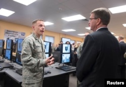 FILE - U.S. Defense Secretary Ashton Carter, right, is briefed on the capabilities of the National Guard Cyber Unit at Joint base Lewis-McChord, Washington, March 4, 2016.